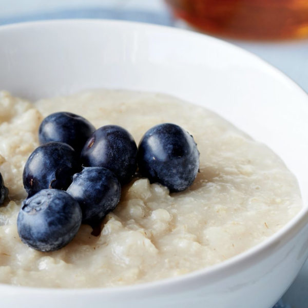 Close up photograph of bowl of gluten free porridge with blueberries